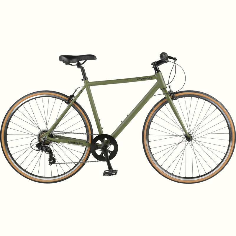 An olive green retrospec Harper Plus 7-Speed bicycle with black saddle and handlebars, and tan-wall tires.